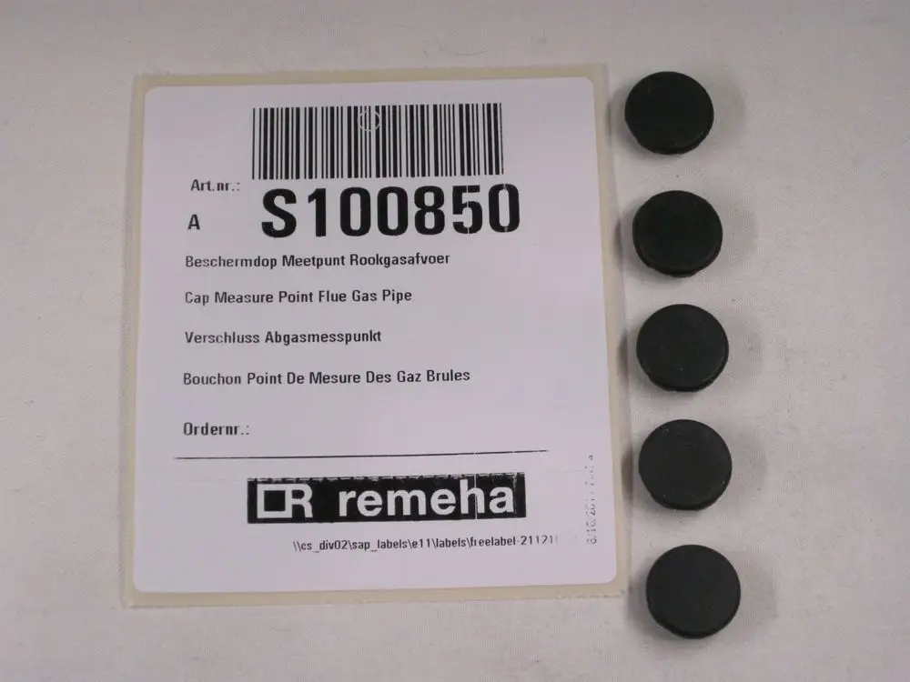 Schwarze Messstopfen auf einer beschrifteten Verpackung von Remeha. Die Stopfen sind rund und flach, angeordnet in einer Reihe.
